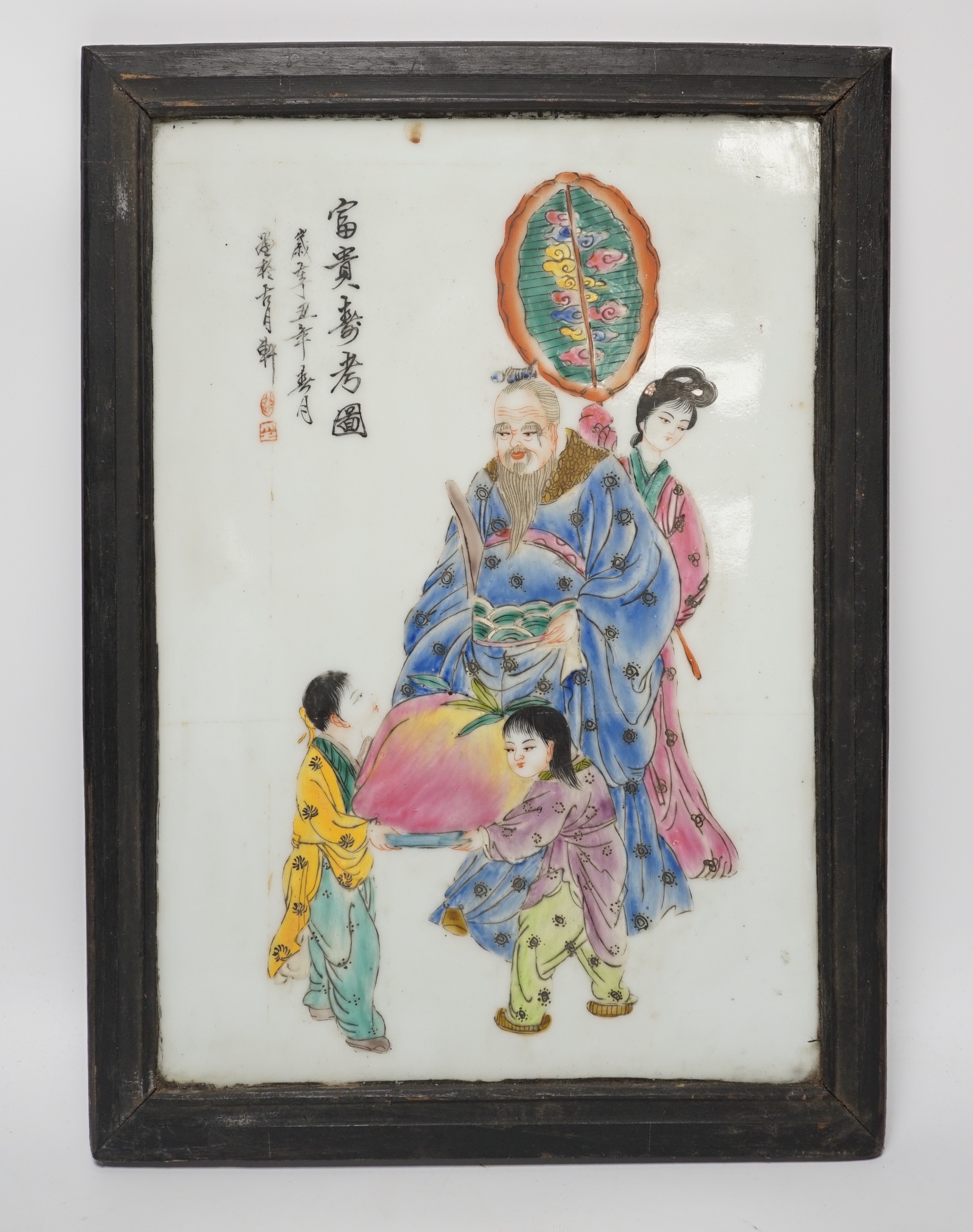 A framed Chinese porcelain plaque decorated with figures and calligraphy, overall 40cm x 29cm